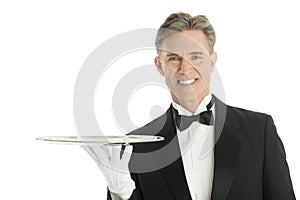 Portrait Of Happy Waiter In Tuxedo With Serving Tray