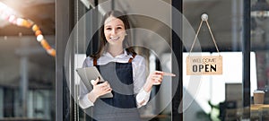 Portrait of a happy waitress standing at restaurant entrance. Portrait of mature business womanattend new customers in