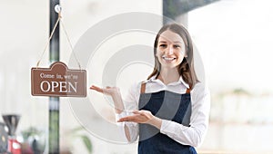 Portrait of a happy waitress standing at restaurant entrance. Portrait of mature business womanattend new customers in