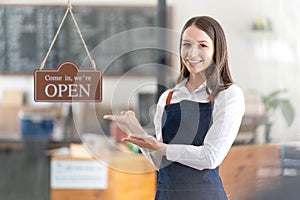 Portrait of a happy waitress standing at restaurant entrance. Portrait of mature business womanattend new customers in