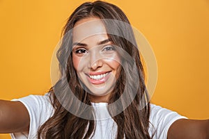 Portrait of happy woman 20s with long hair laughing while taking