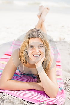 Portrait of happy woman in bikini lying on the beach