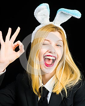 Portrait of a happy woman in bunny ears winking. Closeup of winking bunny girl face. Pretty bunny girl winking and show