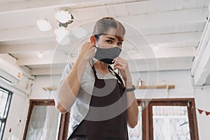 Portrait of happy woman cafe and restaurant owner with face mask.