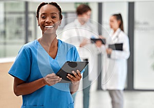 Portrait of happy woman doctor working on a digital tablet and smile while working at a hospital. Black female nurse