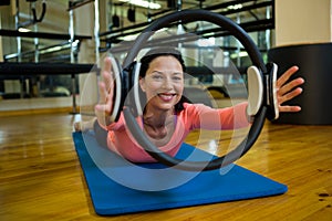 Portrait of happy woman exercising with pilates ring