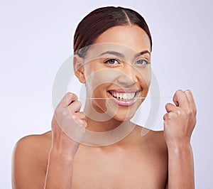 Portrait, happy and woman flossing teeth on studio background for healthy dental wellness. Female model, oral thread and