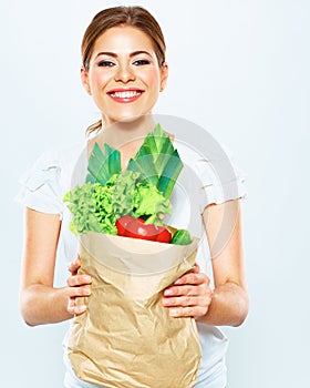 Portrait of happy woman with green vegan food in paper bag.