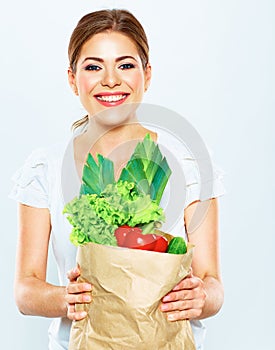 Portrait of happy woman with green vegan food in paper bag