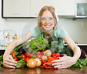 Portrait of happy woman with heap of vegetables