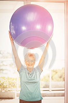 Portrait of happy woman holding blue exercise ball