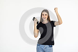 Portrait of a happy woman holding mobile phone and celebrating a win isolated over white background