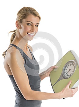 Portrait Of Happy Woman Holding Weight Scale