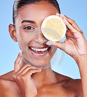 Portrait, happy woman and lemon on eyes in studio for vitamin c cosmetics, natural beauty and detox. Face of indian