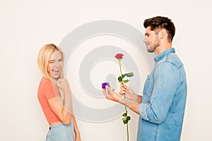 Portrait of happy woman and man holding rose and box with wedding ring