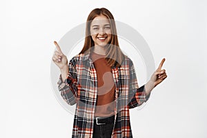 Portrait of happy woman pointing at sale, showing discounts sideways, two choices, variants of items with discounts