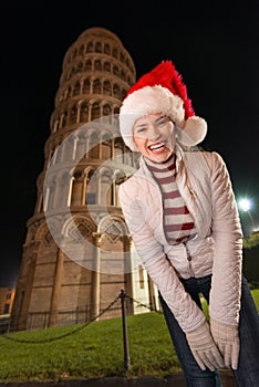 Portrait of happy woman in Santa hat near Leaning Tower of Pisa