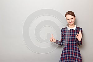 Portrait of happy woman showing okay gesture, giving thumb up sign