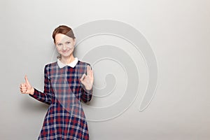 Portrait of happy woman showing okay gesture, giving thumb up sign