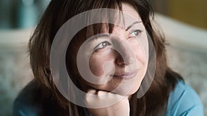 portrait of happy woman sitting on sofa at home and dreaming, happy positive woman, cinematic shot