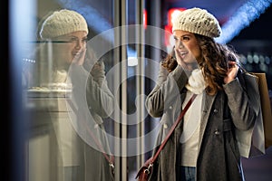 Portrait of happy woman spending time with christmas shopping outdoors in city.