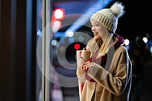 Portrait of happy woman spending time with christmas shopping outdoors in city.