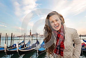 Portrait of happy woman traveler on embankment in Venice, Italy