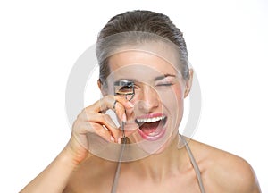 Portrait of happy woman using eyelash curler