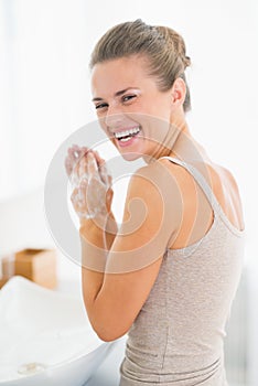 Portrait of happy woman washing hands with soap