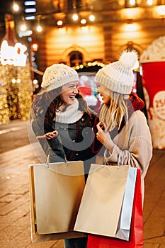 Portrait of happy women enjoying christmas shopping together in the city