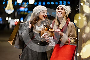 Portrait of happy women enjoying christmas shopping together in the city