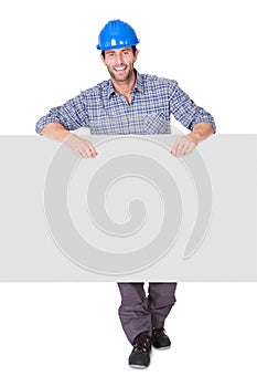 Portrait of happy worker presenting empty banner