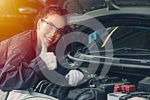 Portrait happy working woman work for auto mechanic job in garage hand thumbs up sign for good condition car engine