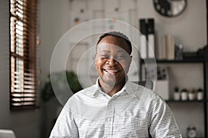 Portrait of a happy young African American businessman smiling in his home office.