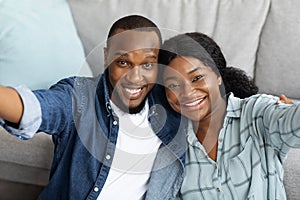 Portrait Of Happy Young African American Couple Taking Selfie Together At Home