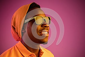 Portrait of a happy young african american man smiling on black neon background