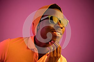 Portrait of a happy young african american man smiling on black neon background