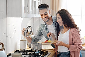 Portrait Of Happy Young Arab Couple Cooking Healthy Food In Kitchen Together