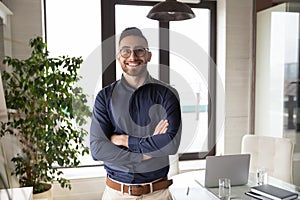 Portrait of happy young arabian businessman standing in office.