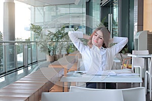 Portrait of happy young Asian business woman feeling relax and good in her office.