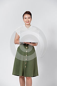 Portrait of happy young asian girl using laptop computer isolated over white background