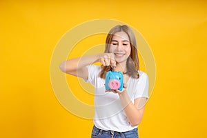 Portrait happy young asian woman holding piggybank saving money for future and business earning income