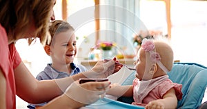 Portrait Of Happy Young Baby In High Chair being fed