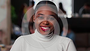 Portrait of happy young beautiful 20s gen-z black business woman with red lips smiling at camera at light trendy office.