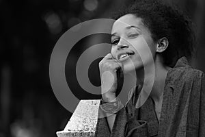 Portrait of happy young beautiful African woman at the park in black and white