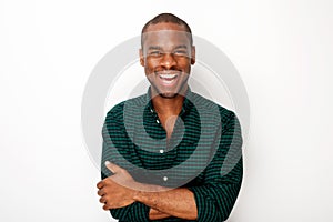 Happy young black guy smiling with arms crossed against isolated white background