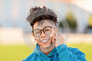 Portrait of happy young black student guy with wireless earbuds