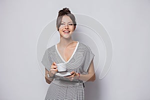 Portrait of a happy young business woman holding cup of coffee isolated over white background.
