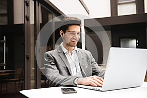 Portrait of a happy young businessman in earphones