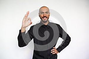 Portrait of happy young businessman making ok gesture